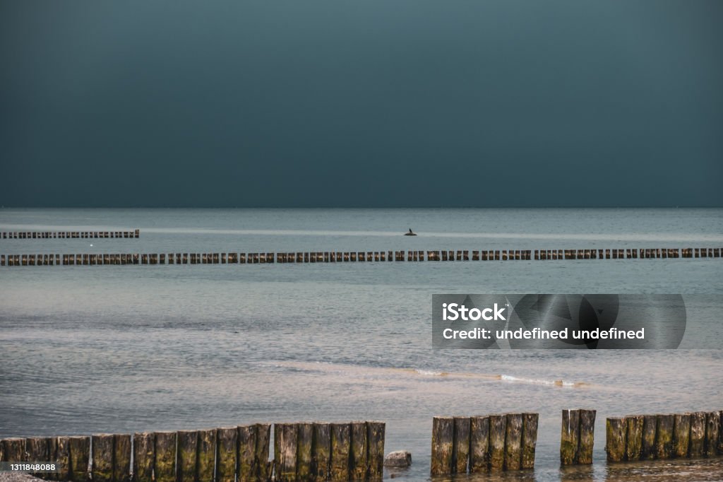 groynes on the beach of the Baltic Sea and the sky is dramatically cloudy the groynes on the beach of the Baltic Sea and the sky is dramatically cloudy Backgrounds Stock Photo