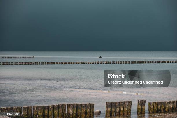 Groynes On The Beach Of The Baltic Sea And The Sky Is Dramatically Cloudy Stock Photo - Download Image Now