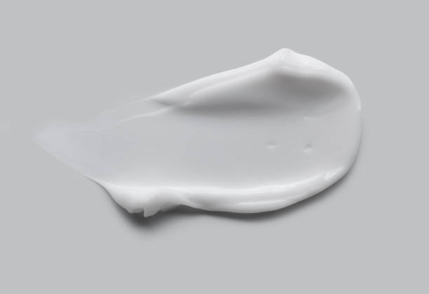 wit beige lichtgroen klei roommasker of oogcrèmesteekproef besmeurd geweven stichtingsstaal dat op veelkleurige achtergrond wordt geïsoleerd - multi vitamine stockfoto's en -beelden