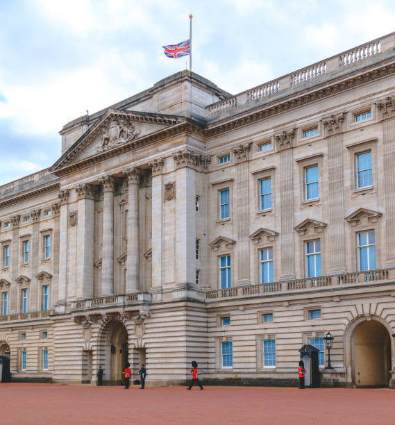 バッキンガム宮殿のユニオンジャック旗は、ロンドン、英国の半分のマストで飛んでいます - palace buckingham palace london england famous place ストックフォトと画像