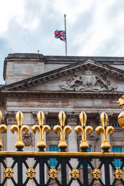 flaga union jack w pałacu buckingham leci na pół masztu w londynie, wielka brytania - palace buckingham palace london england famous place zdjęcia i obrazy z banku zdjęć