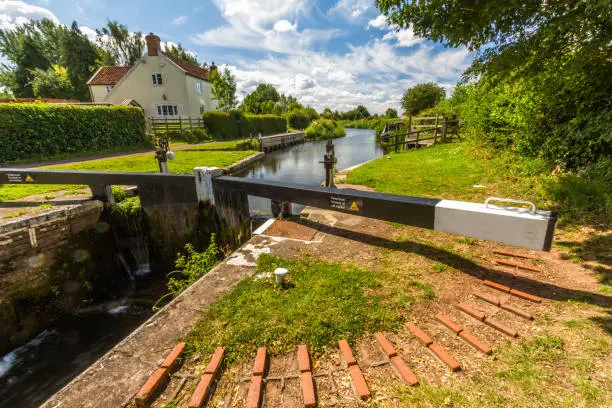 Picturesque canal lock in the UK on sunny summer day. Taunton and Bridgewater Canal, Maunsel Lock, UK, wide angle.