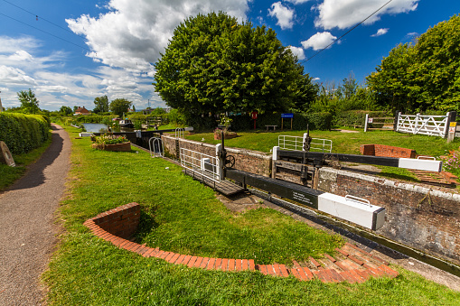 Picturesque canal lock in the UK on sunny summer day. Taunton and Bridgewater Canal, Maunsel Lock, UK, wide angle, copyspace at top.