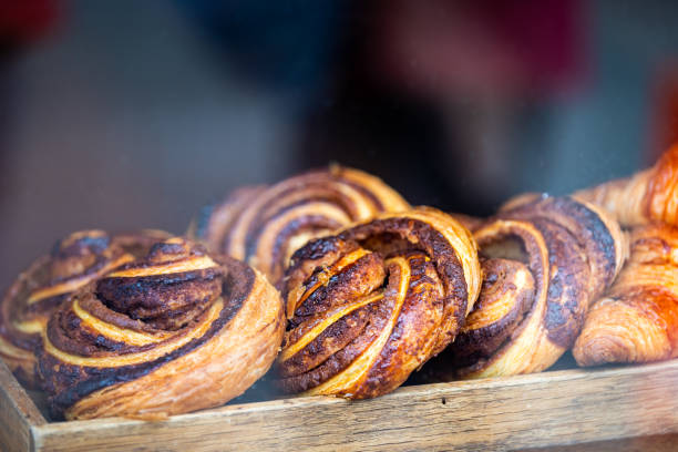 ulica laugavegur w centrum miasta z piekarnią sklep sklep wyświetlacz okno rogalika, francuski i duński bułeczki cynamon wir rolki w reykjaviku, islandia - food and drink croissant french culture bakery zdjęcia i obrazy z banku zdjęć