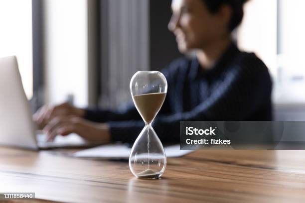 Close Up Hourglass Measuring Time Indian Businesswoman Working Stock Photo - Download Image Now