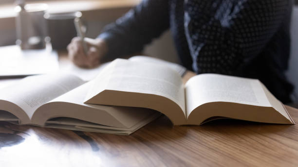 istock Close up young woman student writing notes from textbook 1311858444