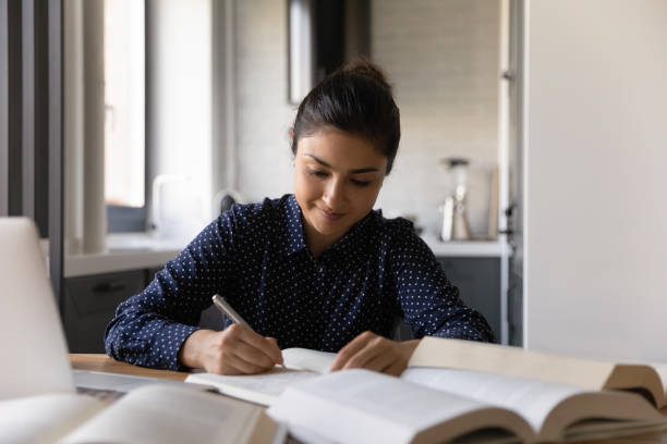 istock Close up Indian woman writing notes, studying, reading textbook 1311858455