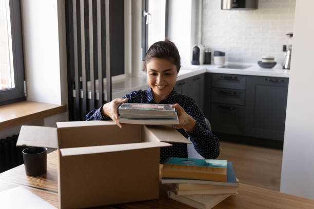 istock Smiling Indian young woman unpacking parcel with internet order 1311858465