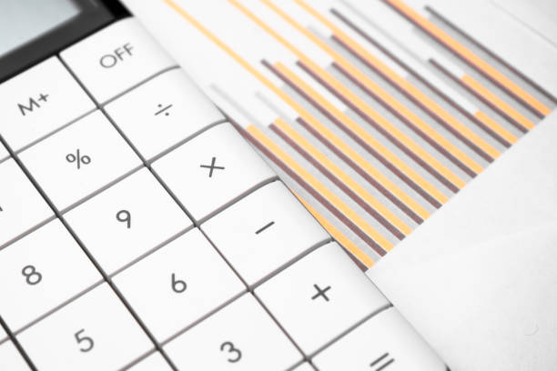 istock calculator and pen with blue business charts, graphs, information and reports background for financial and business concepts 1311862480