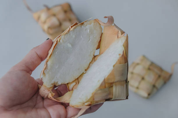 istock Female hands holding a sliced open ketupat 1311862752