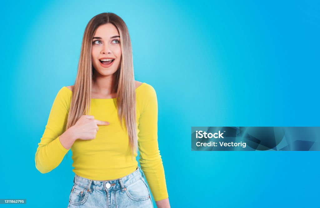 Young Woman pointing on herself and looking at camera with confident smiling face Pointing At Self Stock Photo