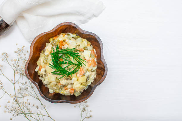 Tradition New Year and Christmas Russian salad "Olivier"on white rustic background. Boiled vegetables and meat with mayonnaise in wooden bowl top view. The most famous starter in Russian cuisine. sauces table turkey christmas stock pictures, royalty-free photos & images