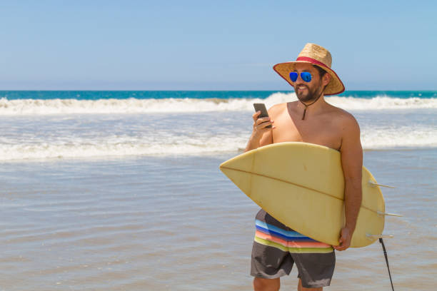 istock A latin fit man using his cellphone to do a streaming while surfing at Monteverde, Santa Elena Province, Ecuador, Latin America 1311870357