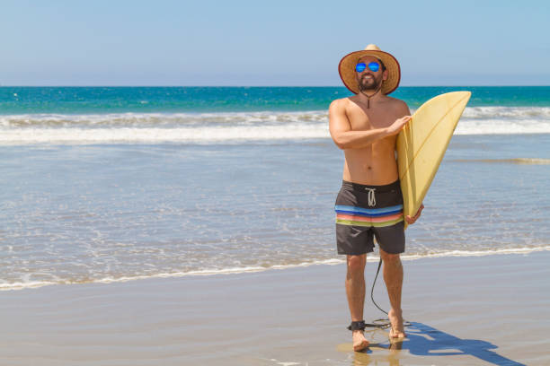 a latin fit man surfing at monteverde, guayas province, ecuador, latin america - surfboard fin imagens e fotografias de stock