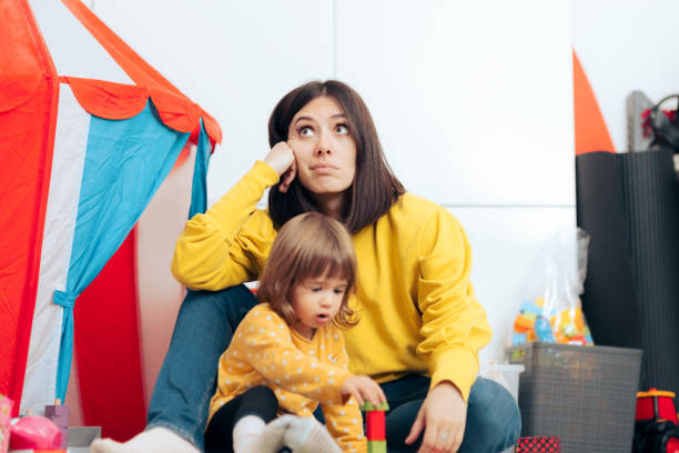 istock Tired Bored Mother Watching her Daughter Playing at Home 1311875014