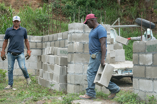 April 4, 2021 Narajal, Dominican Republic. men carrying blocks and stacking at a construction site.