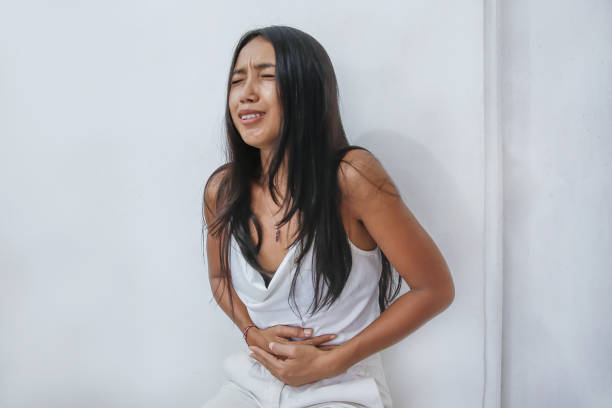 indonesische frau leidet bauchschmerzen - eileiterschwangerschaft stock-fotos und bilder
