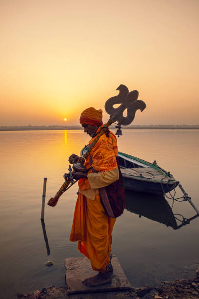 hindu-pilger bietet gebete am ufer des heiligen ganges in varanasi, uttar pradesh - indian ethnicity sadhu india pilgrim stock-fotos und bilder