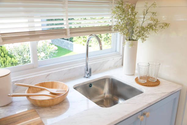istock Clean new sink in stylish kitchen interior by the window. 1311880523