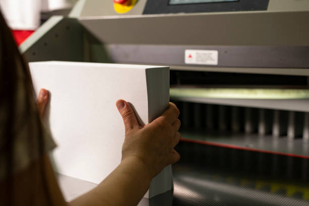 istock Woman prepare paper for cutting sheets close up view 1311882722