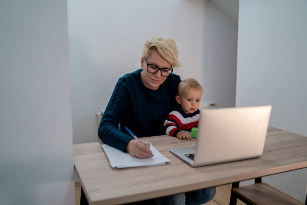 istock mother and her baby boy using laptop at her home 1311886703