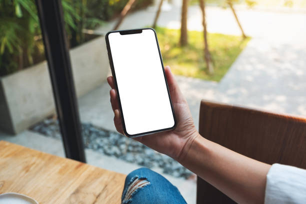 istock a woman holding mobile phone with blank white desktop screen 1311889207