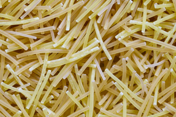 istock Egg noodles or spaghetti pasta, macaroni, noodle texture background macro closeup Top View. Concept of healthy eating, protein diet and vegetarianism. 1311893983