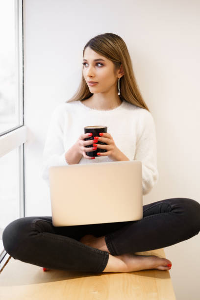 istock Young female at cafe using laptop and drinking latte 1311897774