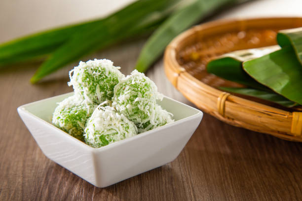 Ondeh ondeh is a traditional Malay snack made of rice ball filled with brown sugar, coated in grated coconut. Ondeh ondeh is a traditional Malay snack made of rice ball filled with brown sugar, coated in grated coconut. traditional malaysian food stock pictures, royalty-free photos & images