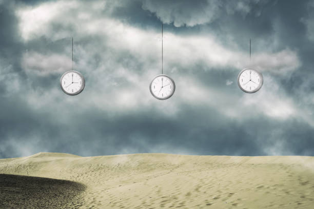 istock Clock from the cloudy sky, over the sand dunes. Different times. Time, sand. Time concept. 1311905224