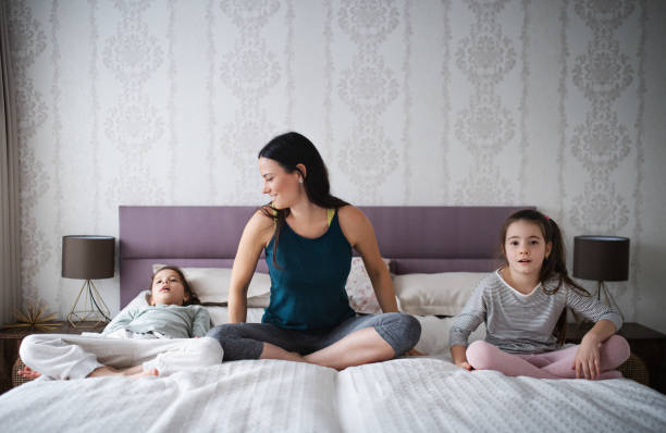 istock Mother with daughters on bed after exercise indoors at home. 1311907441