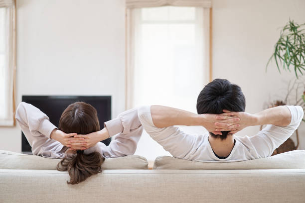 hombres y mujeres asiáticos relajándose en la sala de estar - stretching boyfriend indoors lifestyles fotografías e imágenes de stock