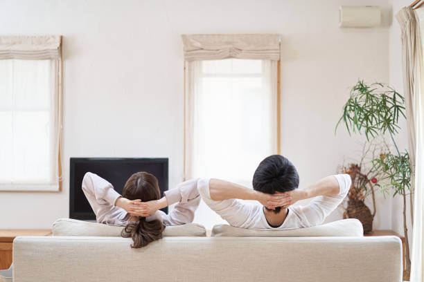 hombres y mujeres asiáticos relajándose en la sala de estar - stretching boyfriend indoors lifestyles fotografías e imágenes de stock