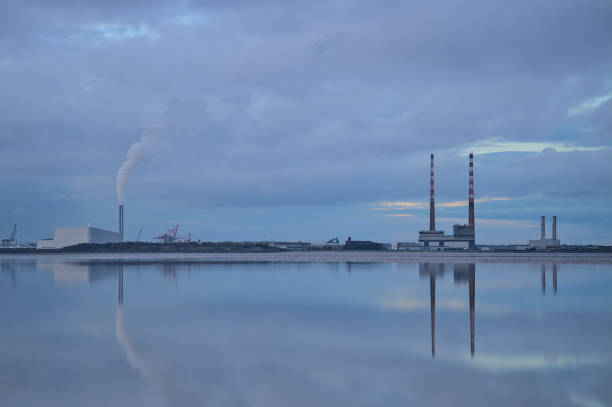 Reflective view of Dublin Waste to Energy (Covanta Plant), Poolbeg CCGT and Pigeon House Power Station view from Blackrock Beach, Dublin, Ireland stock photo