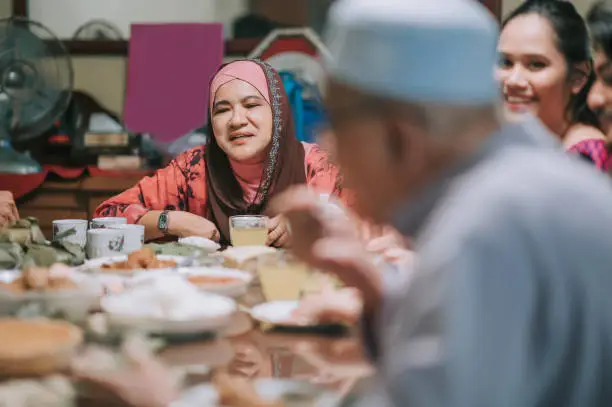 Ramadan hari raya malaysian muslim multi generation family enjoying dinner at home in dining room