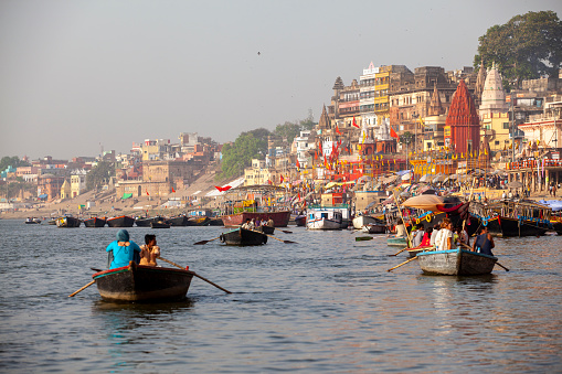 Varanasi, India - April 6, 2010: Boats moored in front of ghats on the River Ganges, Varanasi, Uttar Pradesh, India. Varanasi has always attracted a large number of pilgrims and worshippers from time immemorial.