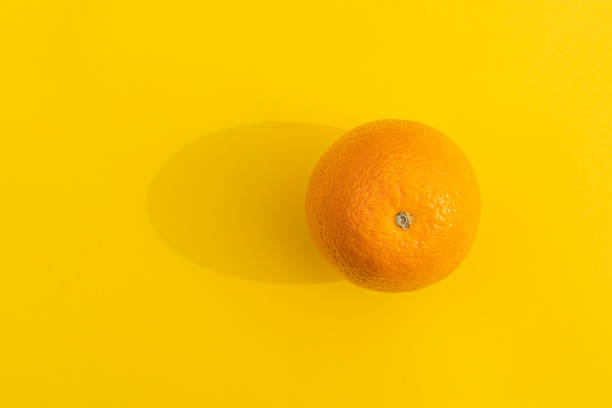 istock orange with a hard shadow on a colorful background 1311914350