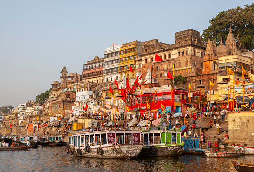 Varanasi, India - April 6, 2010: Boats moored in front of ghats on the River Ganges, Varanasi, Uttar Pradesh, India. Varanasi has always attracted a large number of pilgrims and worshippers from time immemorial.
