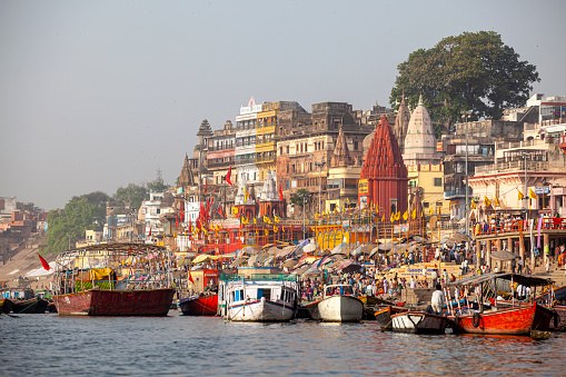 Varanasi, India - April 6, 2010: Boats moored in front of ghats on the River Ganges, Varanasi, Uttar Pradesh, India. Varanasi has always attracted a large number of pilgrims and worshippers from time immemorial.