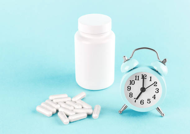 istock Alarm clock and herbal capsules. 1311922451