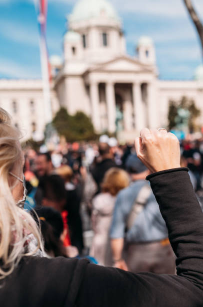 Female protester raising her fist up Young woman with a raised fist protesting in the street in front of the government building, while she is wearing a protective face mask.
2021 climate justice stock pictures, royalty-free photos & images