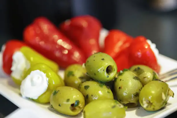 Freshly garnished green olives and red pointed peppers stuffed with cream cheese