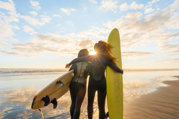 istock Two female friends going for surfing. 1311930468