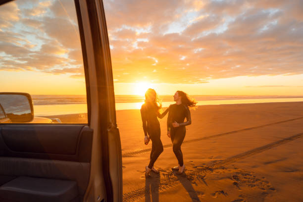 istock Two young woman on beach at sunset time. 1311930506