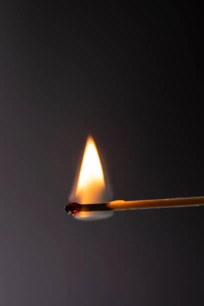 istock close up of a burning match against dark background 1311930823