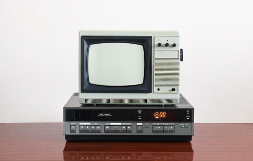 Old TV with VCR on the background of wallpaper.