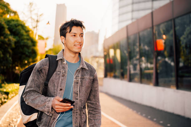 istock Young man using smart phone under sunlight on the streets. 1311931763