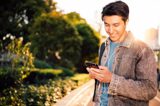 istock Young man using smart phone under sunlight on the streets. 1311931807