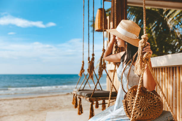 viajera asiática mujer viajar y relajarse en swing en la cafetería de playa en koh chang verano tailandia - turismo vacaciones fotografías e imágenes de stock