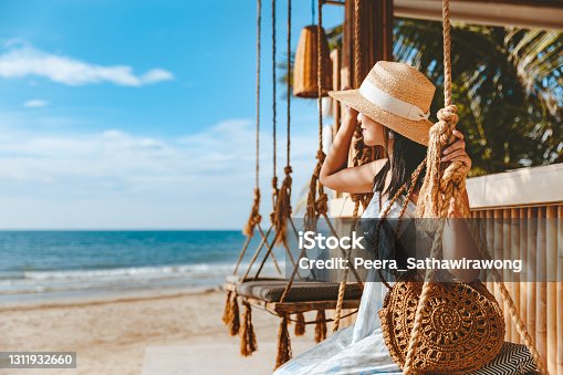istock Traveler asian woman travel and relax on swing in beach cafe at Koh chang summer Thailand 1311932660